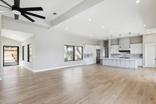 unfurnished living room with light hardwood / wood-style flooring, a wealth of natural light, and ceiling fan