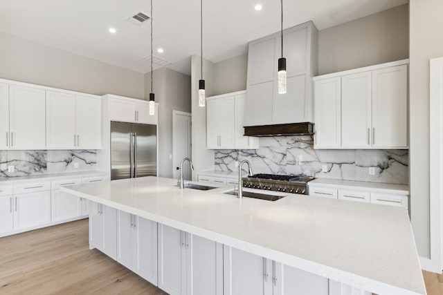 kitchen with a large island, decorative light fixtures, sink, and appliances with stainless steel finishes