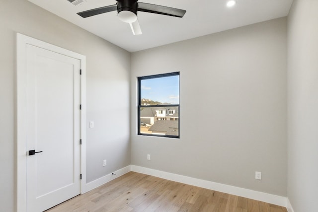 empty room featuring ceiling fan and light hardwood / wood-style flooring