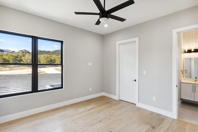 unfurnished bedroom featuring ensuite bath, ceiling fan, and light hardwood / wood-style floors