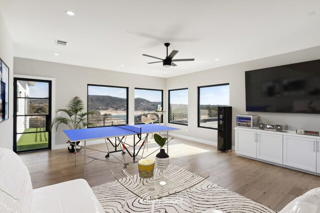 recreation room with light hardwood / wood-style flooring and ceiling fan