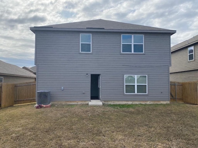 back of property featuring central AC and a lawn