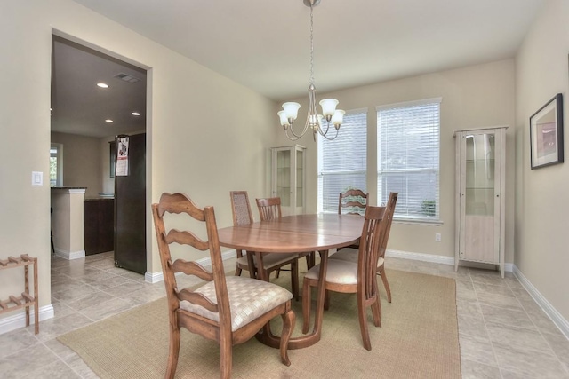 dining space featuring a notable chandelier and light tile patterned floors