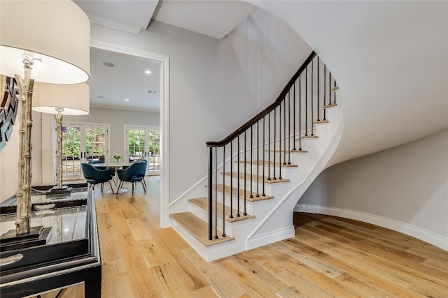 stairway with baseboards, wood finished floors, and recessed lighting
