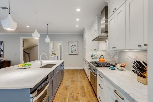 kitchen with a sink, an island with sink, backsplash, wall chimney exhaust hood, and ornamental molding