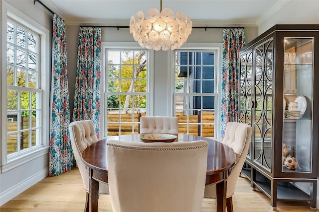 dining space featuring baseboards, wood finished floors, a notable chandelier, and ornamental molding
