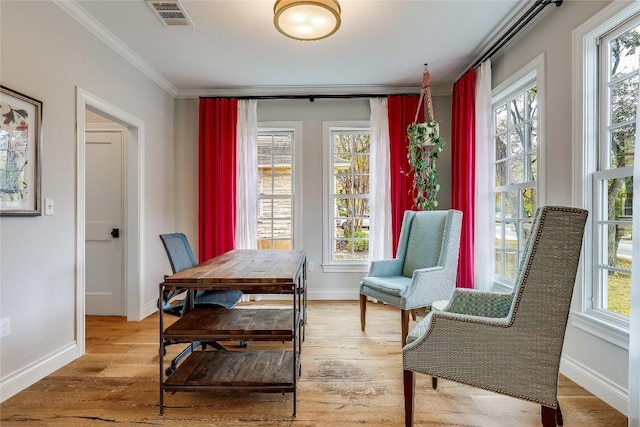 sitting room featuring wood finished floors, visible vents, crown molding, and baseboards