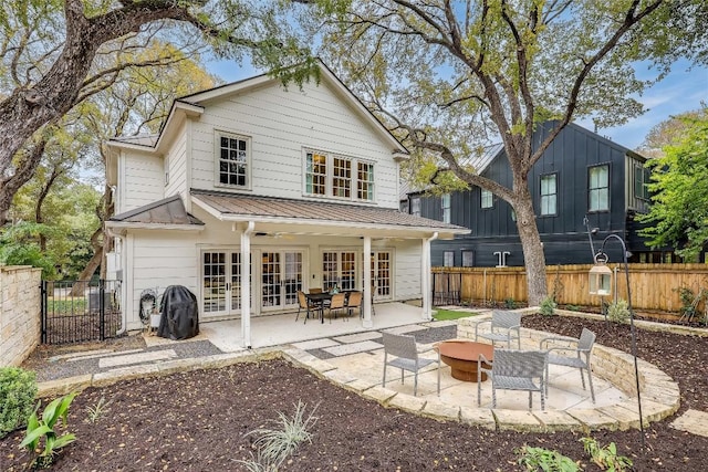 back of property featuring french doors, an outdoor fire pit, and a patio area