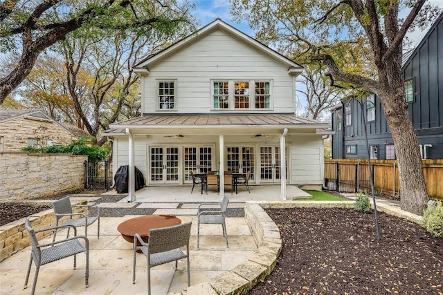 rear view of house featuring french doors, a fenced backyard, metal roof, a patio area, and ceiling fan