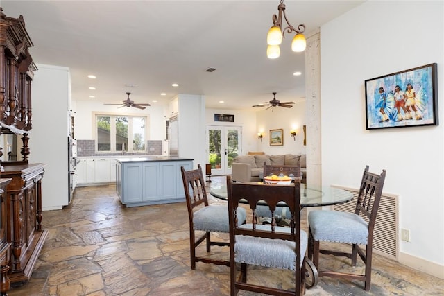 dining area with french doors and ceiling fan with notable chandelier