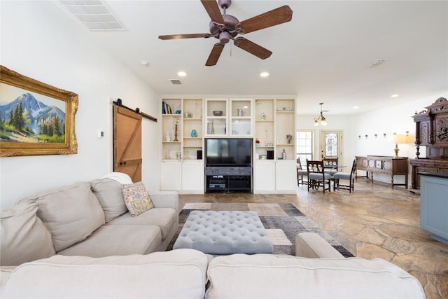 living room featuring a barn door and ceiling fan