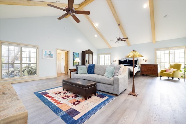 living room with beam ceiling, light wood-type flooring, high vaulted ceiling, and ceiling fan