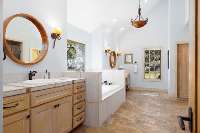 bathroom featuring vanity, tiled tub, and high vaulted ceiling