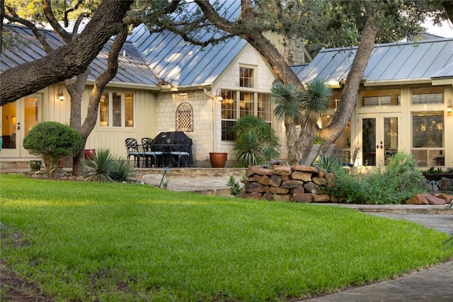 rear view of property featuring a yard and french doors