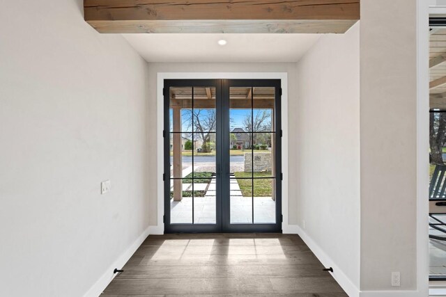 interior space with french doors, dark hardwood / wood-style flooring, and beam ceiling