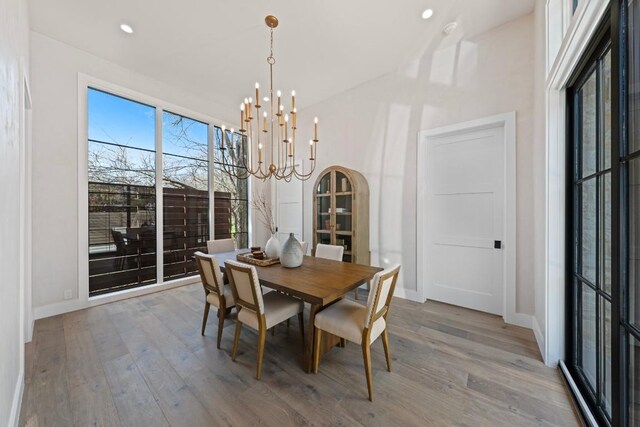 dining area with hardwood / wood-style floors and an inviting chandelier