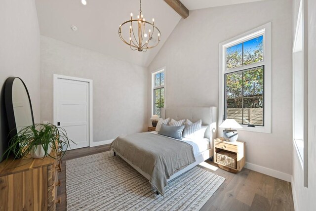 bedroom with wood-type flooring, high vaulted ceiling, an inviting chandelier, and beam ceiling