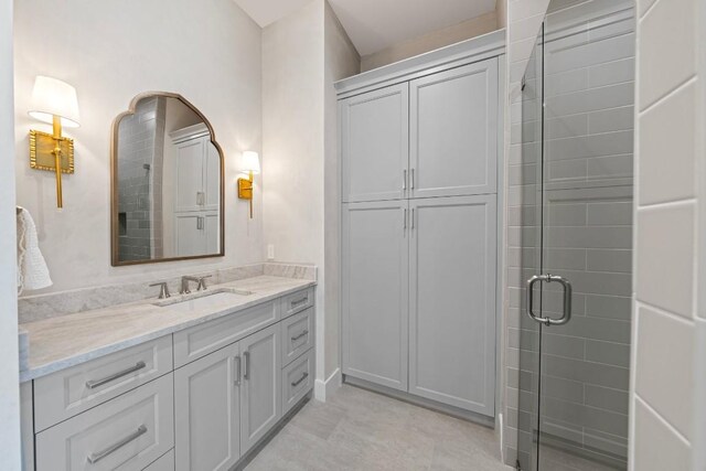 bathroom featuring vanity and a shower with door