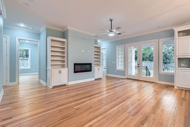 unfurnished living room featuring french doors, ornamental molding, built in shelves, ceiling fan, and light hardwood / wood-style flooring