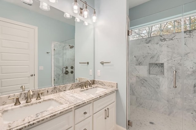 bathroom featuring a shower with door and vanity