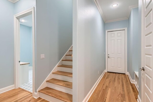 interior space with light wood-type flooring and crown molding