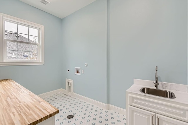 clothes washing area featuring electric dryer hookup, sink, cabinets, and washer hookup