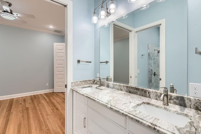 bathroom featuring walk in shower, vanity, ceiling fan, crown molding, and hardwood / wood-style floors