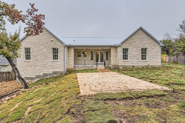 rear view of property featuring a lawn and ceiling fan