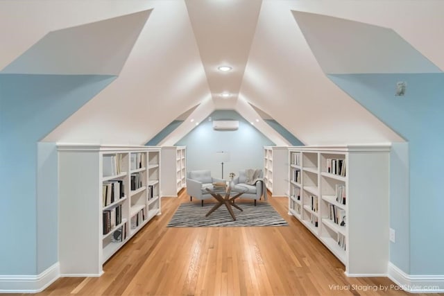 bonus room featuring hardwood / wood-style flooring, lofted ceiling, and a wall unit AC