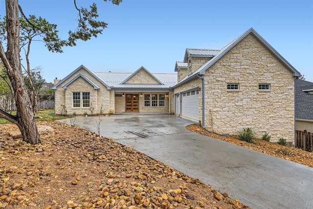 205 Vitex Dr, Lakeway, TX 78734 - view of front of property featuring stone siding, an attached garage, driveway, french doors, and metal roof