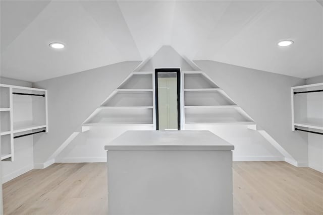 spacious closet featuring light hardwood / wood-style floors and vaulted ceiling