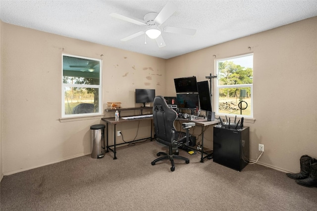 home office with a textured ceiling, carpet floors, and ceiling fan