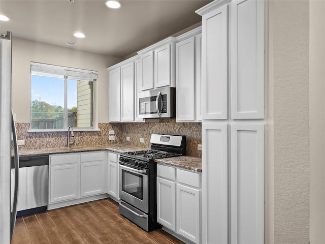 kitchen featuring dark hardwood / wood-style floors, white cabinetry, backsplash, and appliances with stainless steel finishes