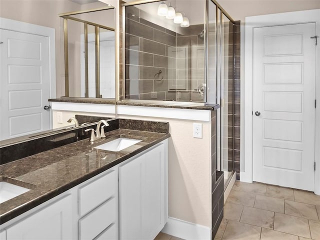 bathroom with tile patterned flooring, vanity, and walk in shower