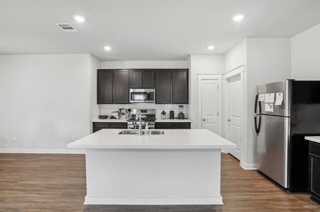 kitchen featuring appliances with stainless steel finishes, sink, a center island with sink, and wood-type flooring