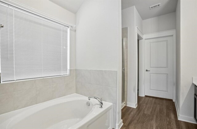 bathroom featuring wood-type flooring, vanity, and separate shower and tub