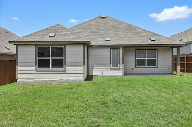 rear view of house featuring a yard