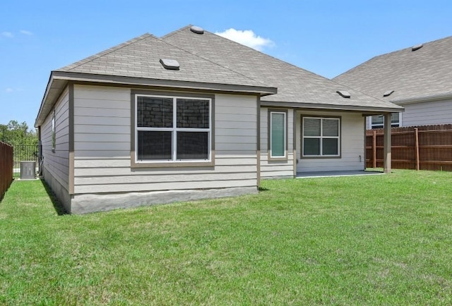 rear view of house featuring a yard and central AC unit