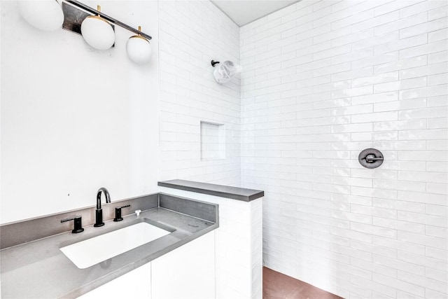 bathroom with tiled shower and sink