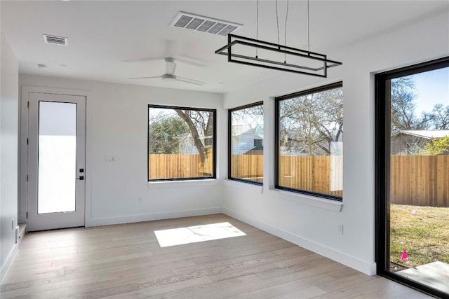 unfurnished sunroom with visible vents and ceiling fan