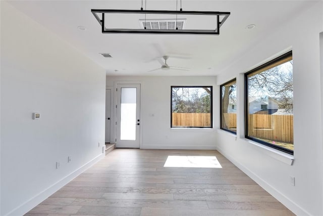 unfurnished sunroom featuring a ceiling fan and visible vents