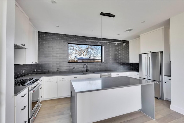 kitchen with a sink, stainless steel appliances, visible vents, and decorative backsplash