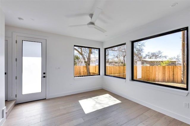 unfurnished sunroom featuring ceiling fan