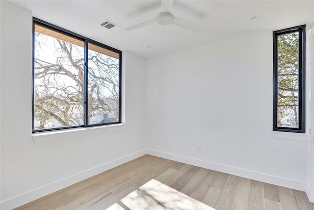 spare room featuring visible vents, baseboards, a healthy amount of sunlight, and light wood-style flooring