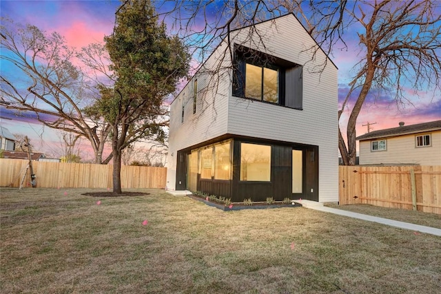 back of property featuring a fenced backyard, board and batten siding, and a yard