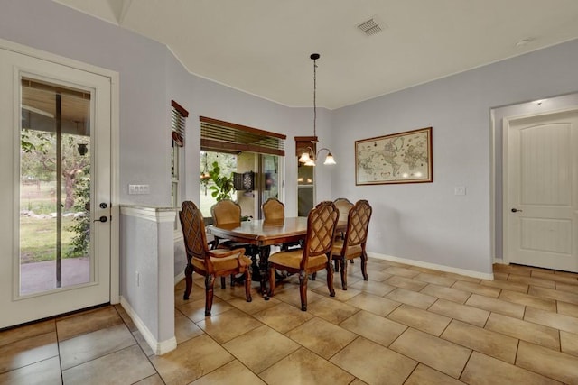 tiled dining room with a notable chandelier and plenty of natural light