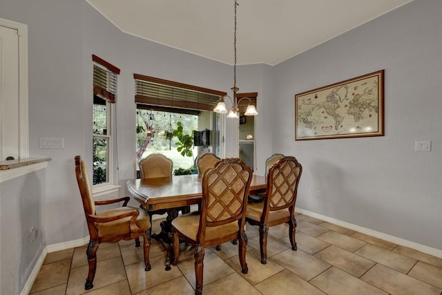 dining area featuring a notable chandelier and light tile patterned flooring