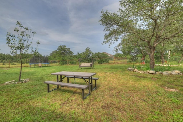 view of community with a lawn and a trampoline