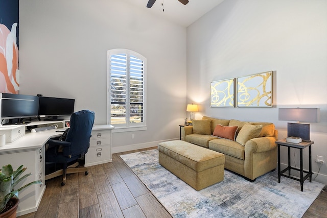 office space featuring ceiling fan, a towering ceiling, and hardwood / wood-style flooring