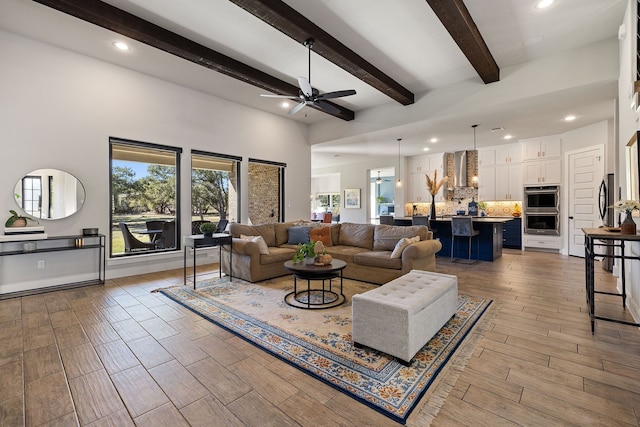 living room featuring ceiling fan and beamed ceiling